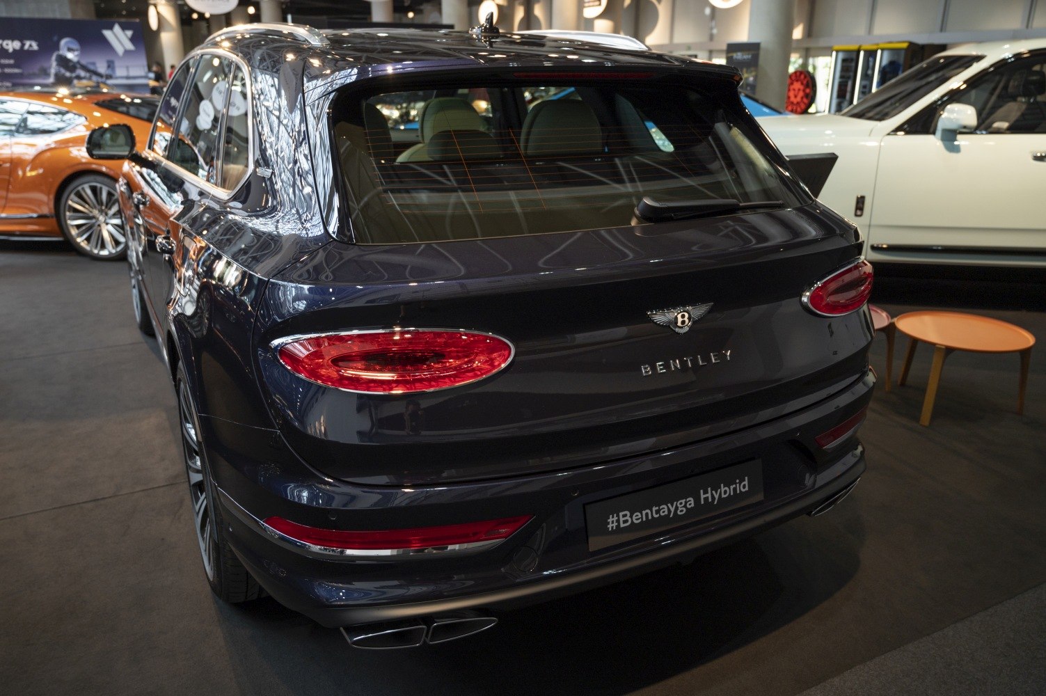 Rear view with hybrid badge, oval tail lights, dual exhausts