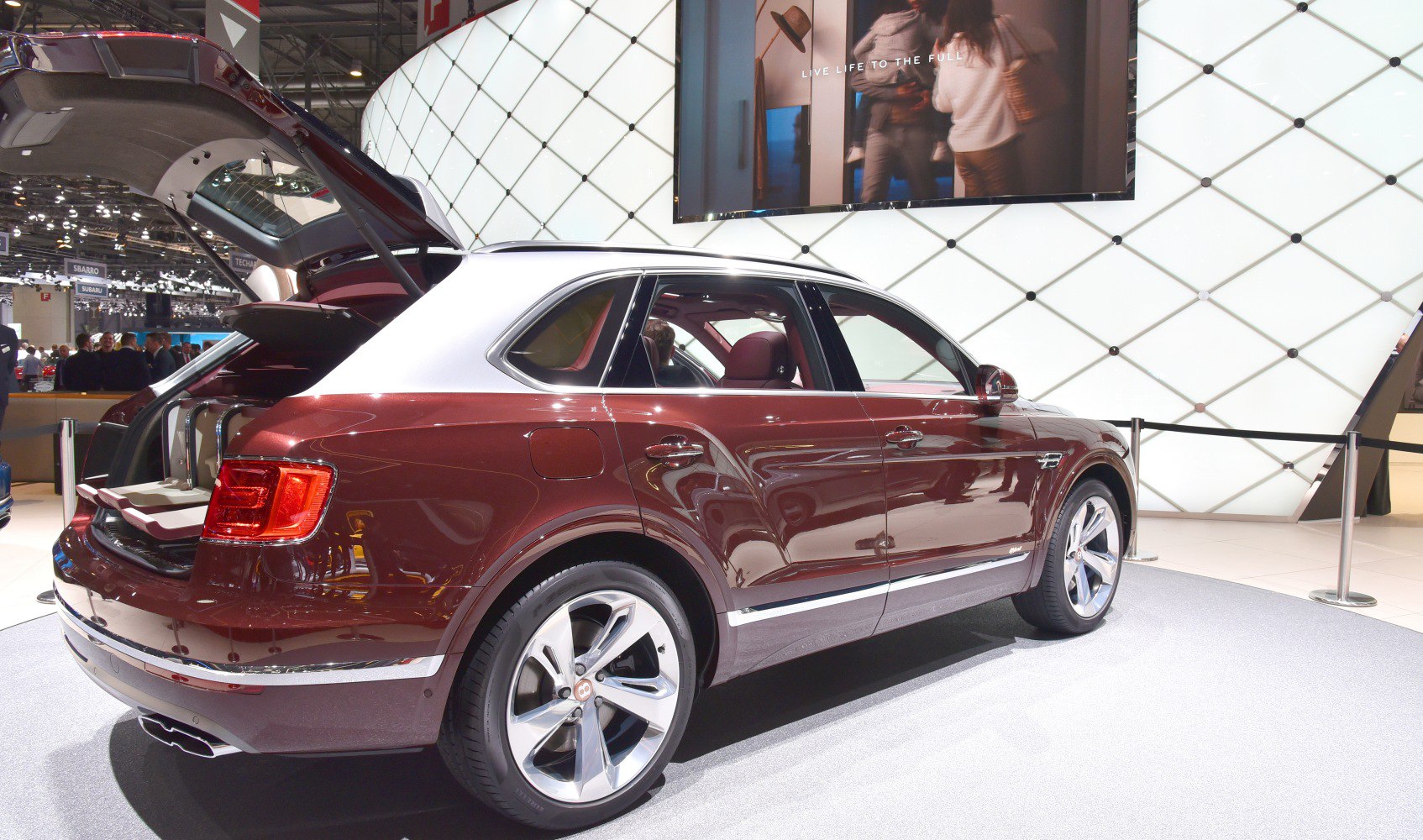 Two-tone luxury SUV with open rear hatch and alloy wheels