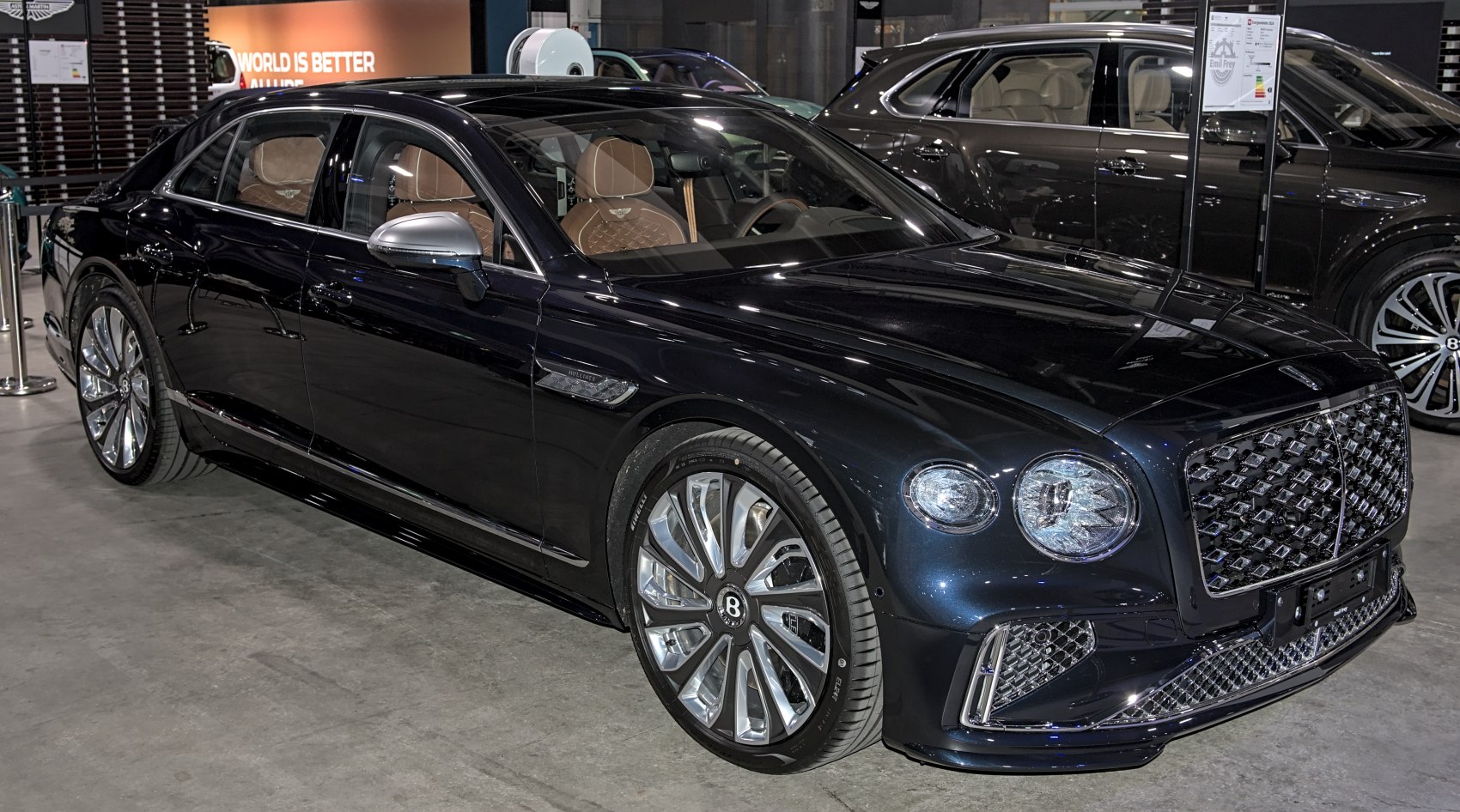Front side view of a luxury sedan with bold grille and intricate alloy wheels.