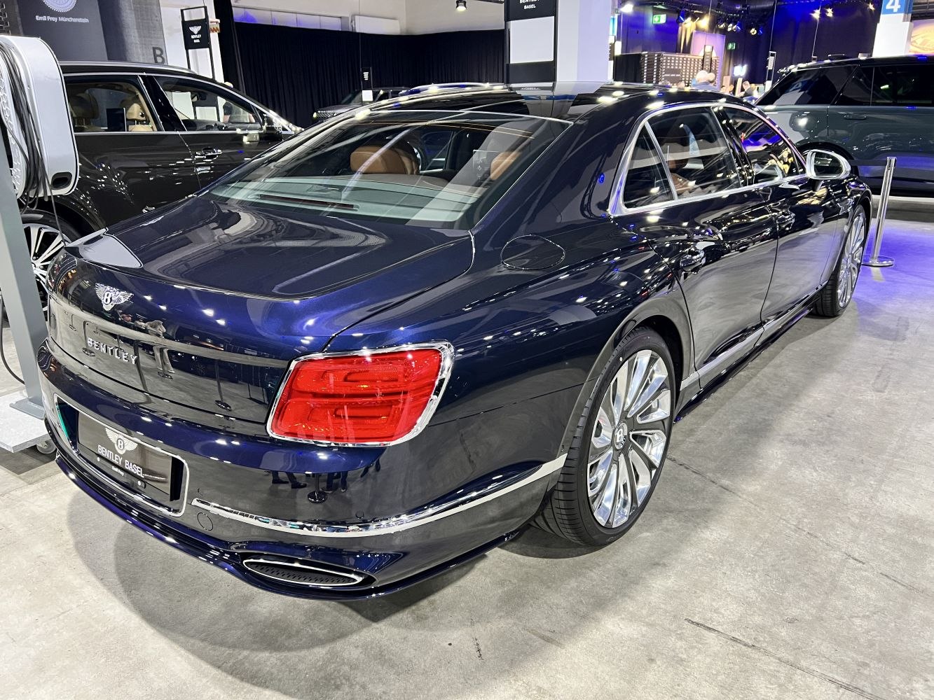 Blue luxury sedan rear with distinctive taillights and chrome accents