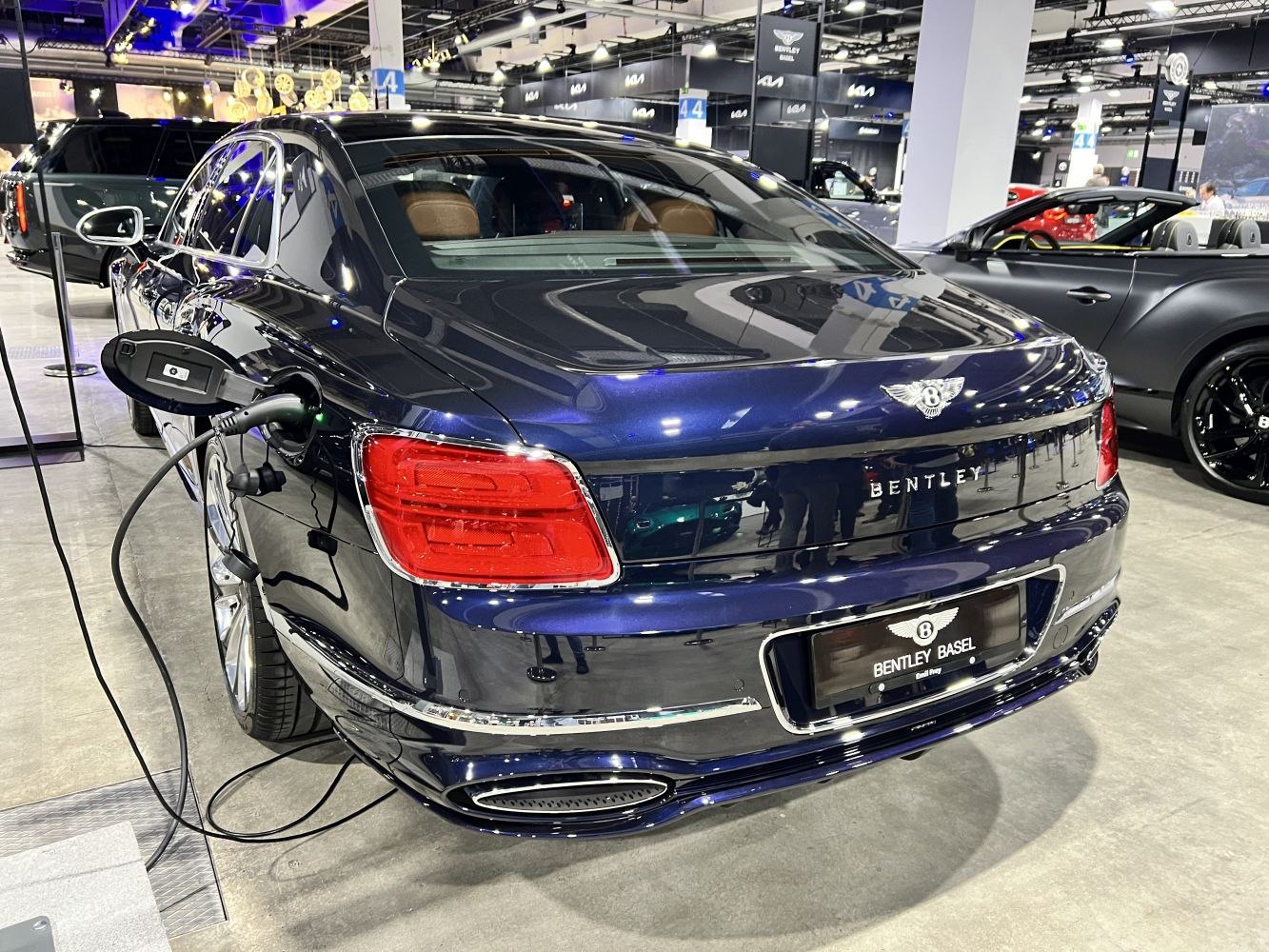 Rear view of luxury sedan with open charging port and distinctive taillights