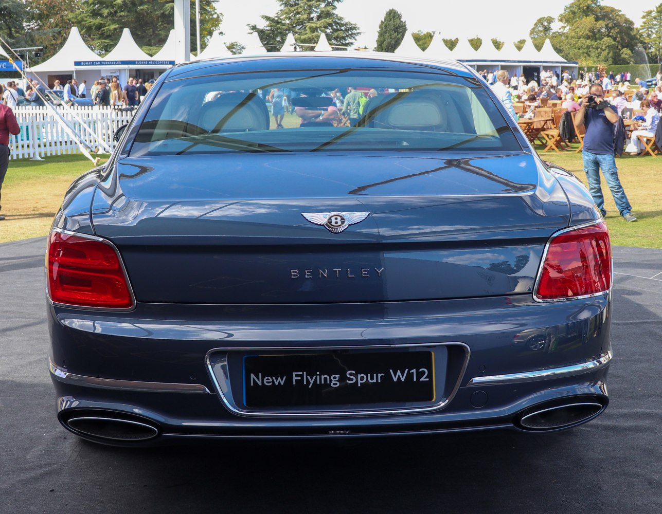 Rear view showing tail lights, Bentley badge, and dual exhaust pipes.
