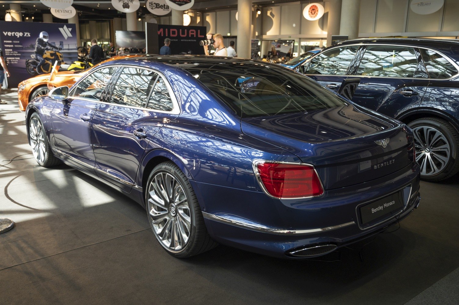 Luxury sedan rear with prominent tail lights and large alloy wheels