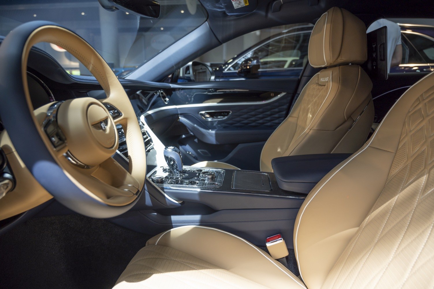 Beige leather seats with diamond stitching and modern dashboard controls