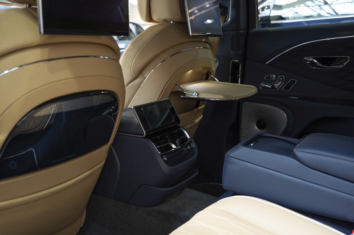 Luxurious rear seats with built-in screens and foldable tray table