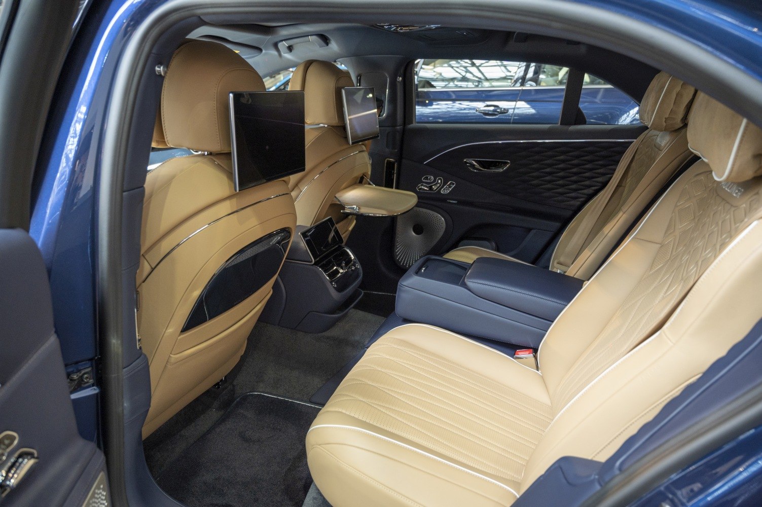 Rear seat interior with dual headrest screens and foldable tray table