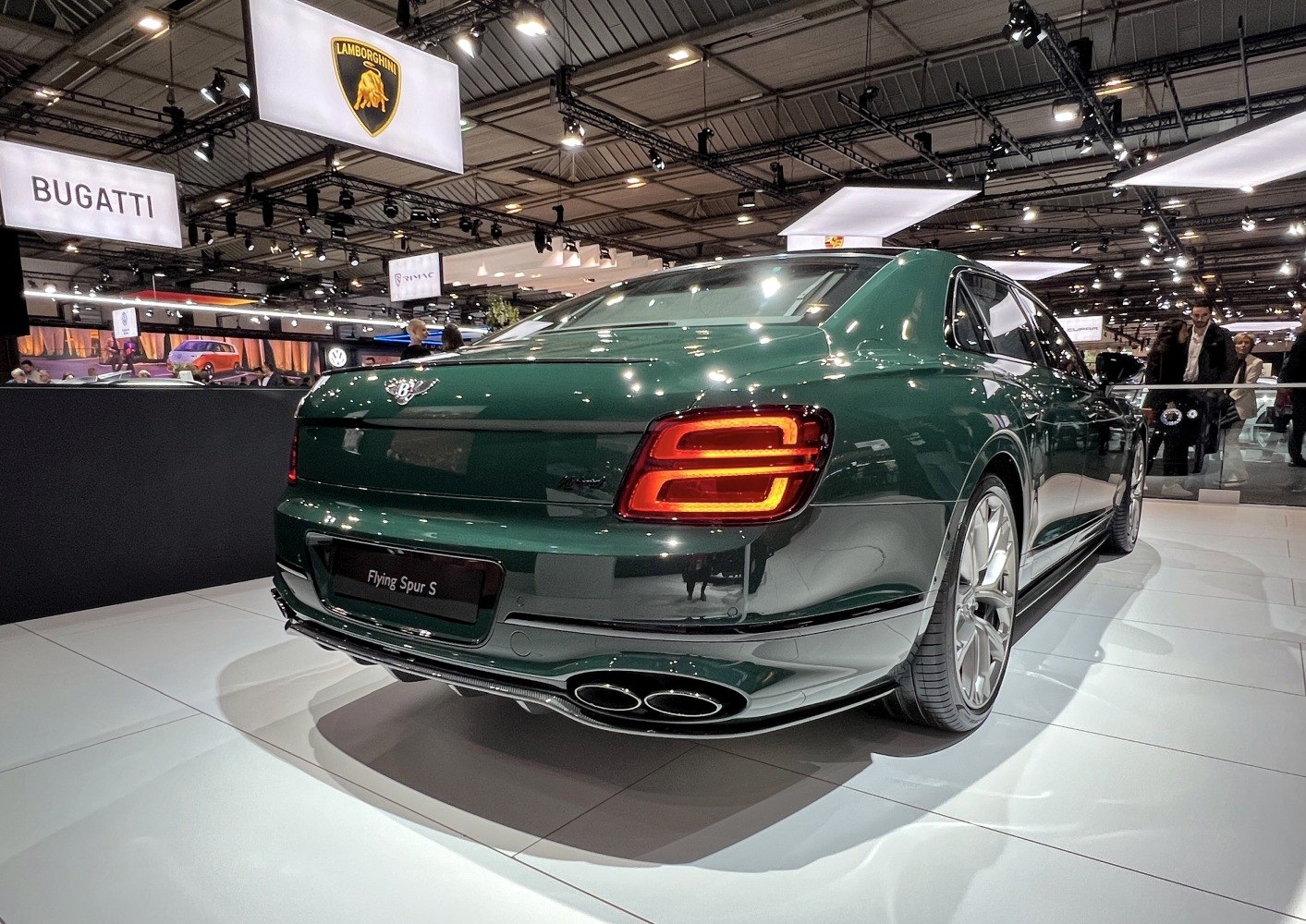 Rear view of luxury green sedan with quad exhausts and LED taillights
