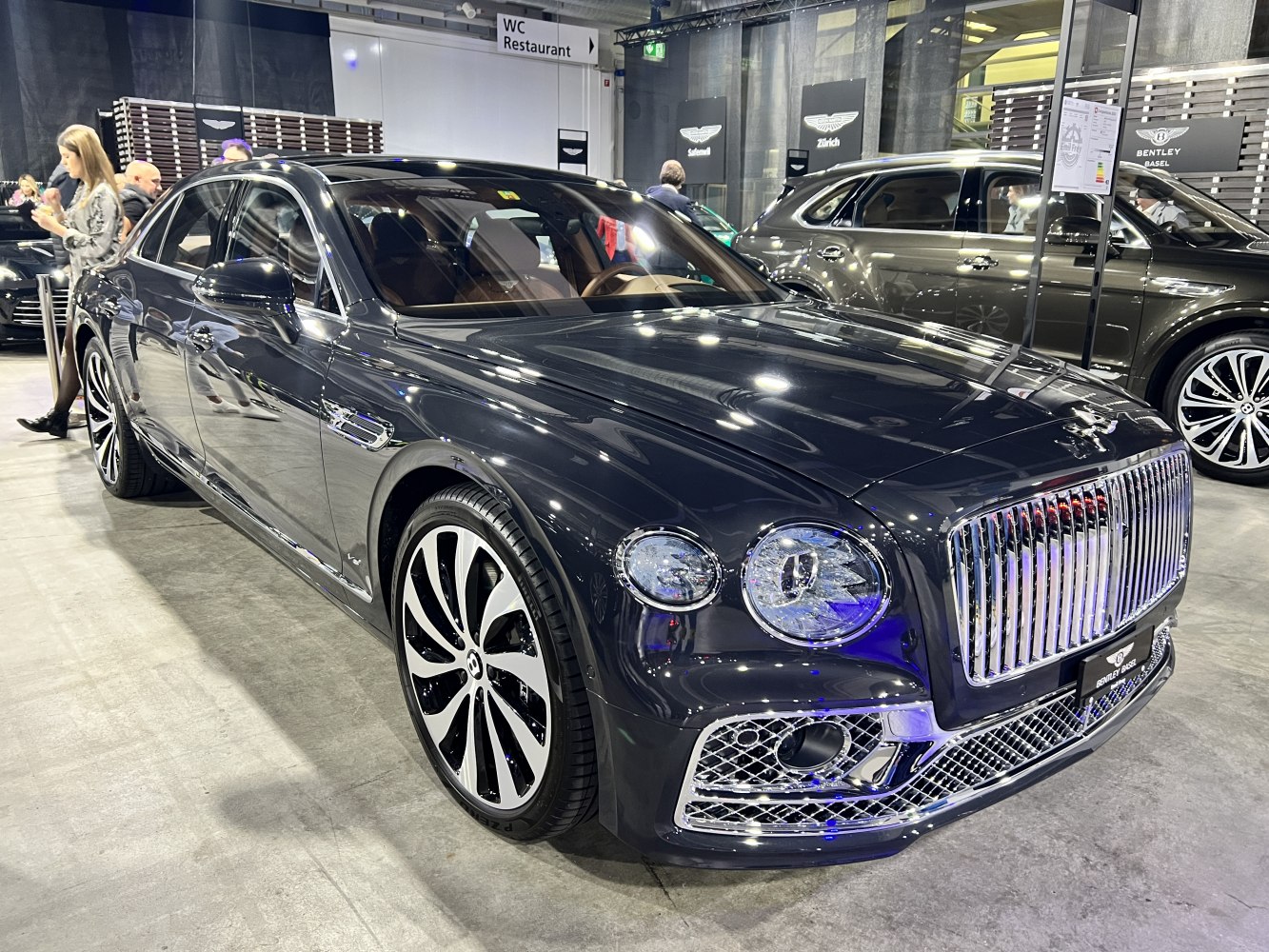 Luxury sedan with large chrome grille and dual round headlights.