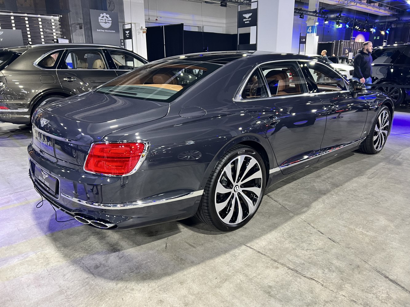 Luxury sedan rear view with dual exhaust and large alloy wheels