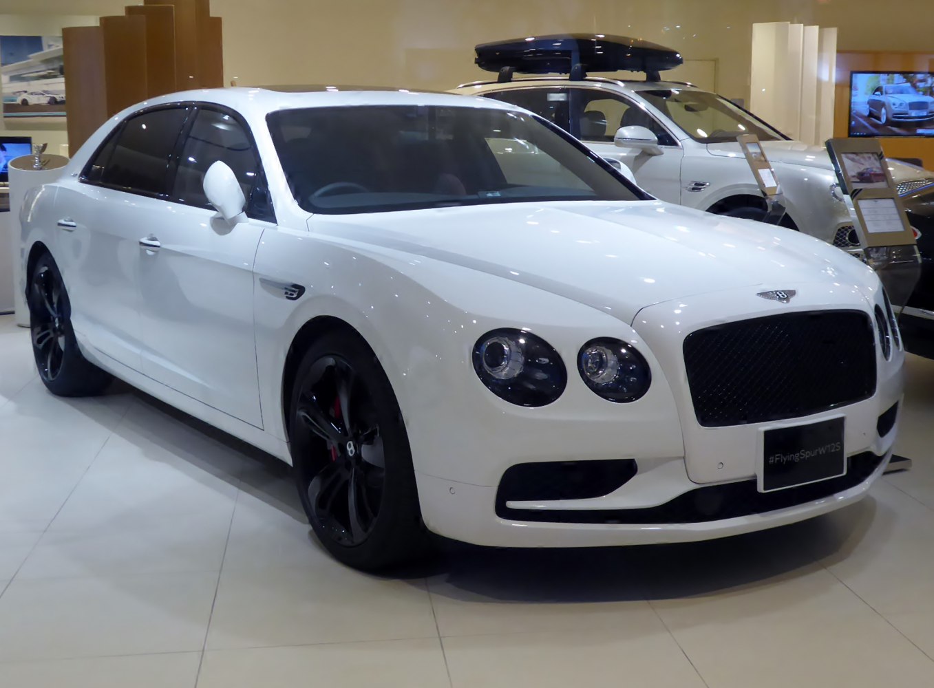 Luxury white sedan with black rims and quad round headlights