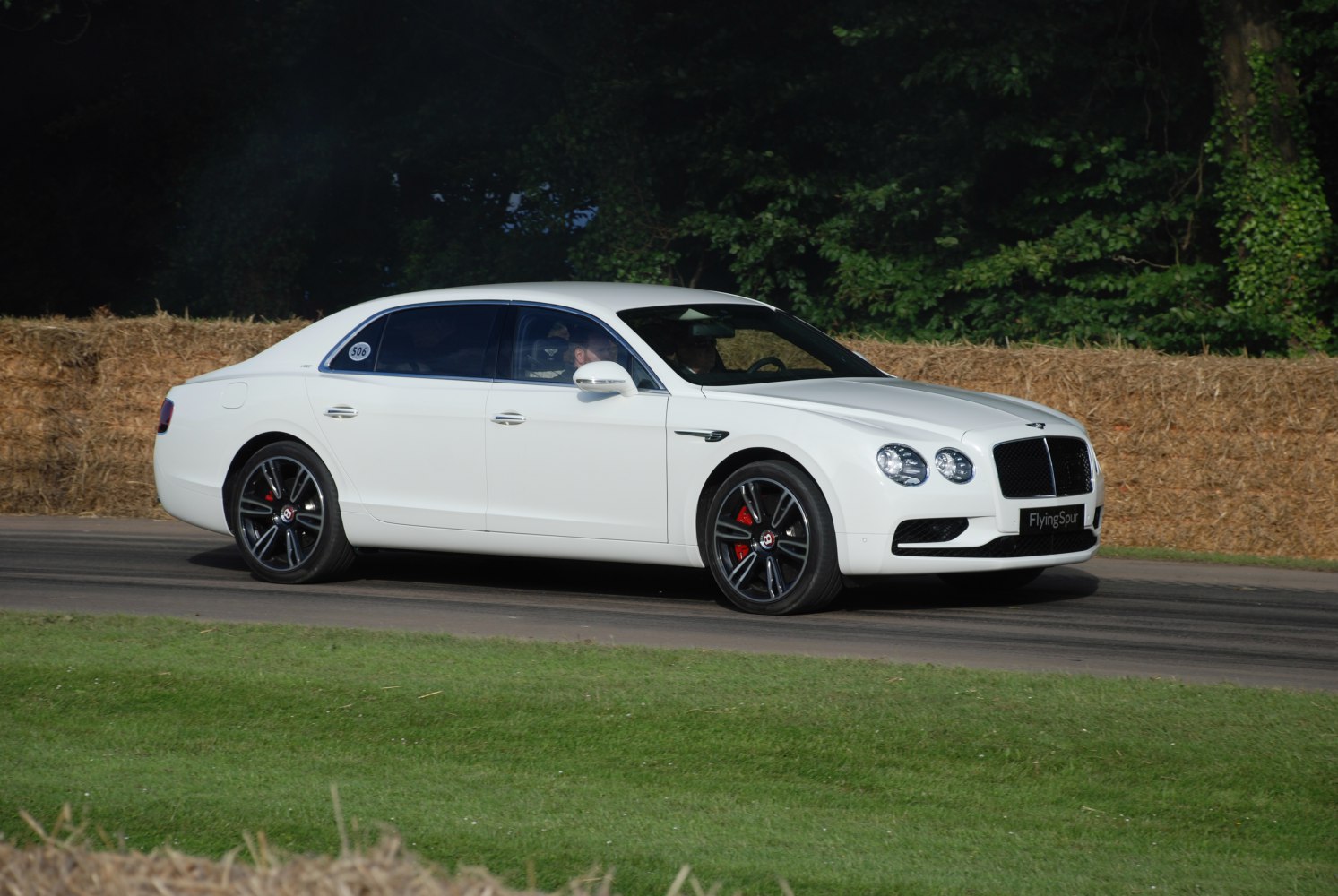 Side profile of luxury sedan with black alloy wheels and red brake calipers