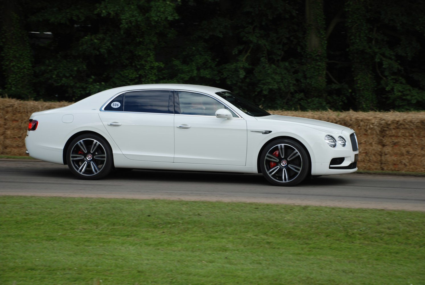 White luxury sedan with tinted windows and distinctive alloy wheels