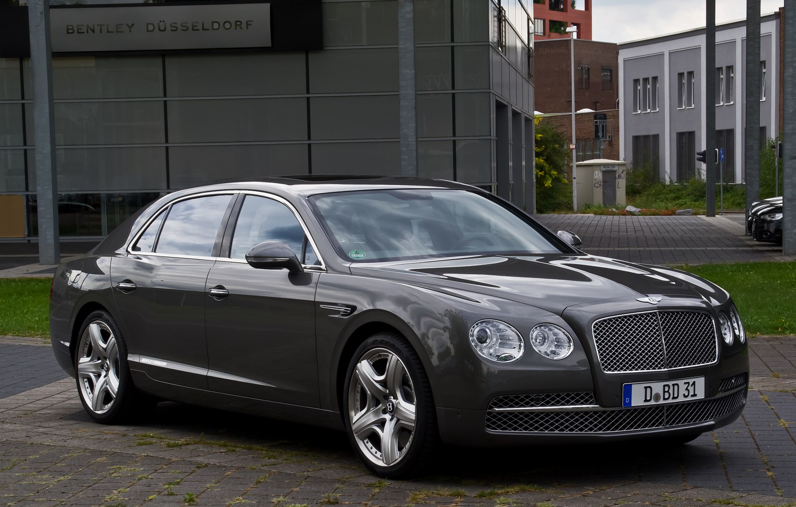 Luxury sedan with large mesh grille and quad round headlights