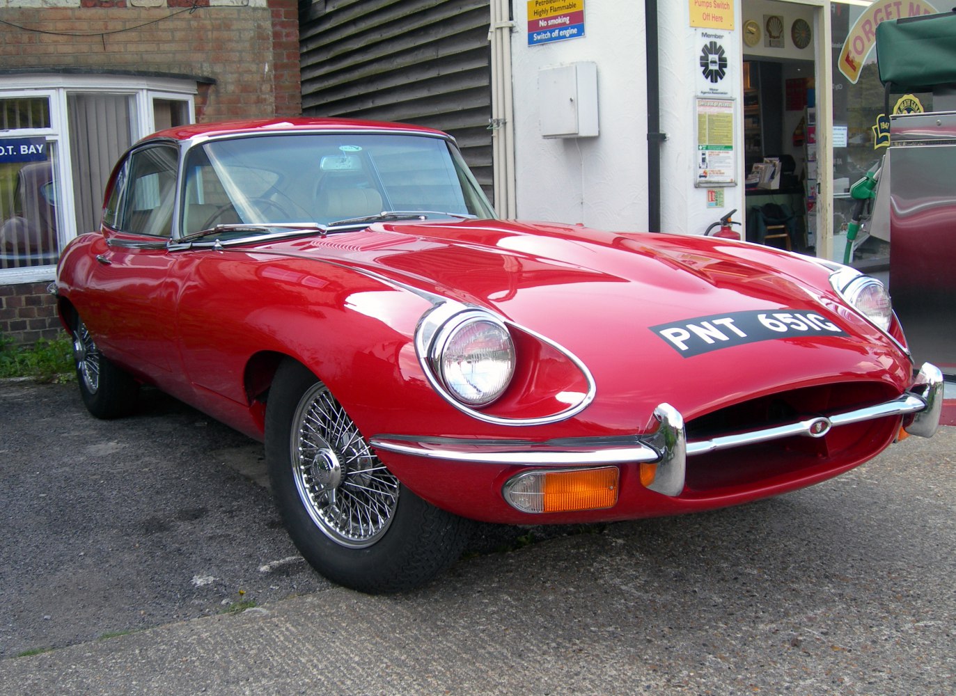 Curved front with round headlights and wire spoke wheels.