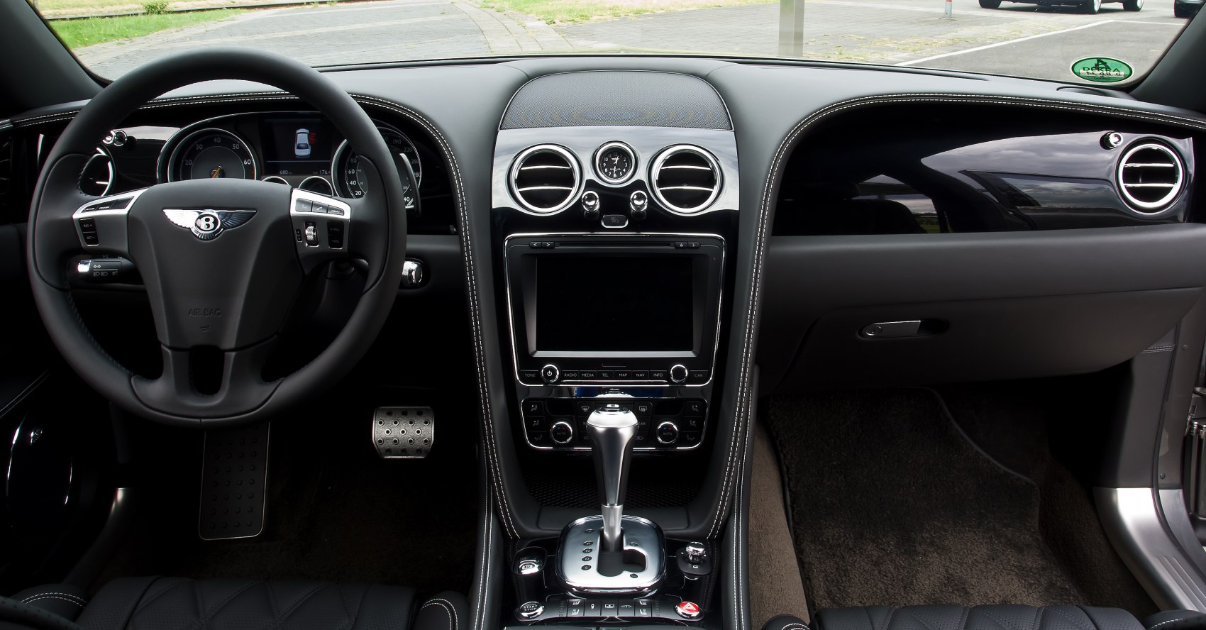 Luxury car interior with steering wheel, dashboard, and center console