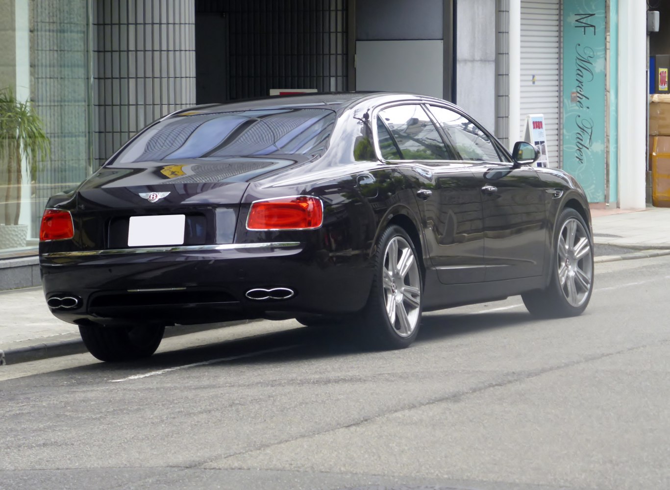 Rear and side view of a luxury sedan with distinctive tail lights and dual exhaust
