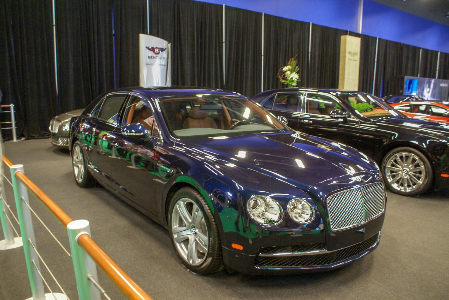 Luxury sedan with dual round headlights and chrome mesh grille