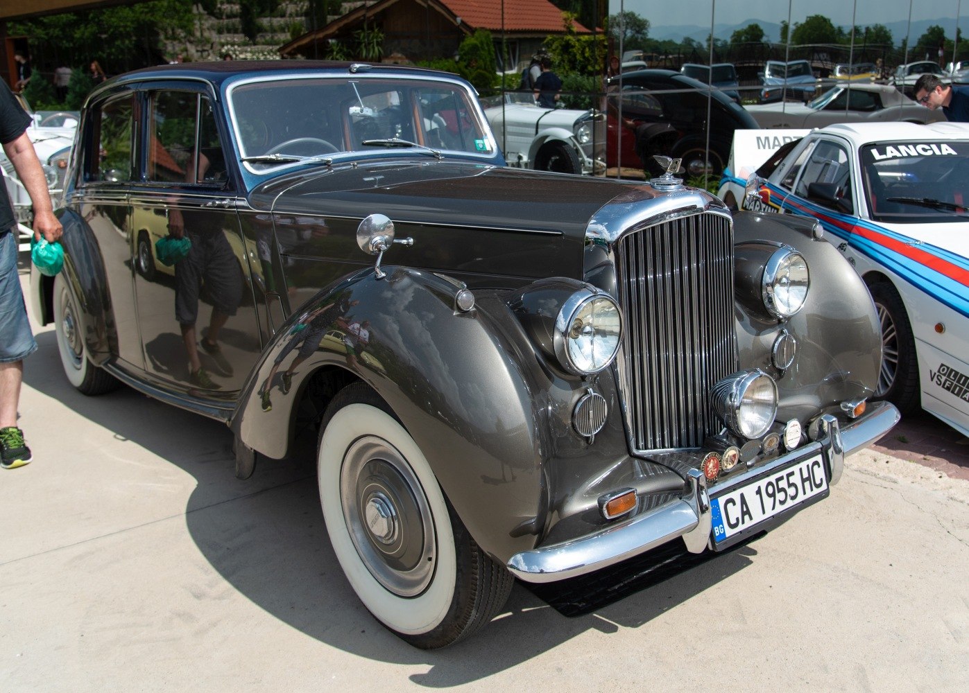 Vintage car front grille and round headlights with whitewall tires