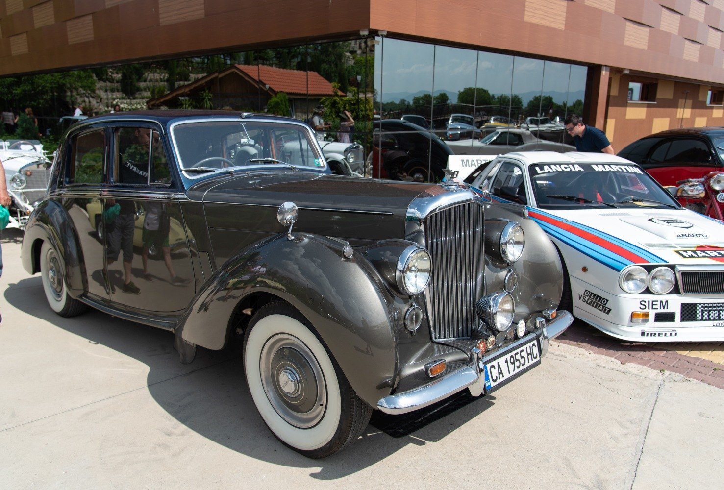 Vintage luxury sedan with rounded fenders, vertical chrome grille, and whitewall tires