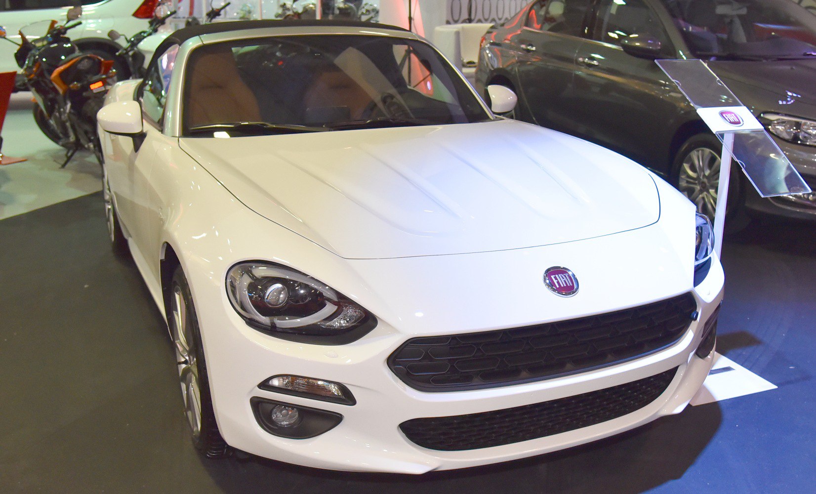 White sports roadster with distinctive headlights and front grille.