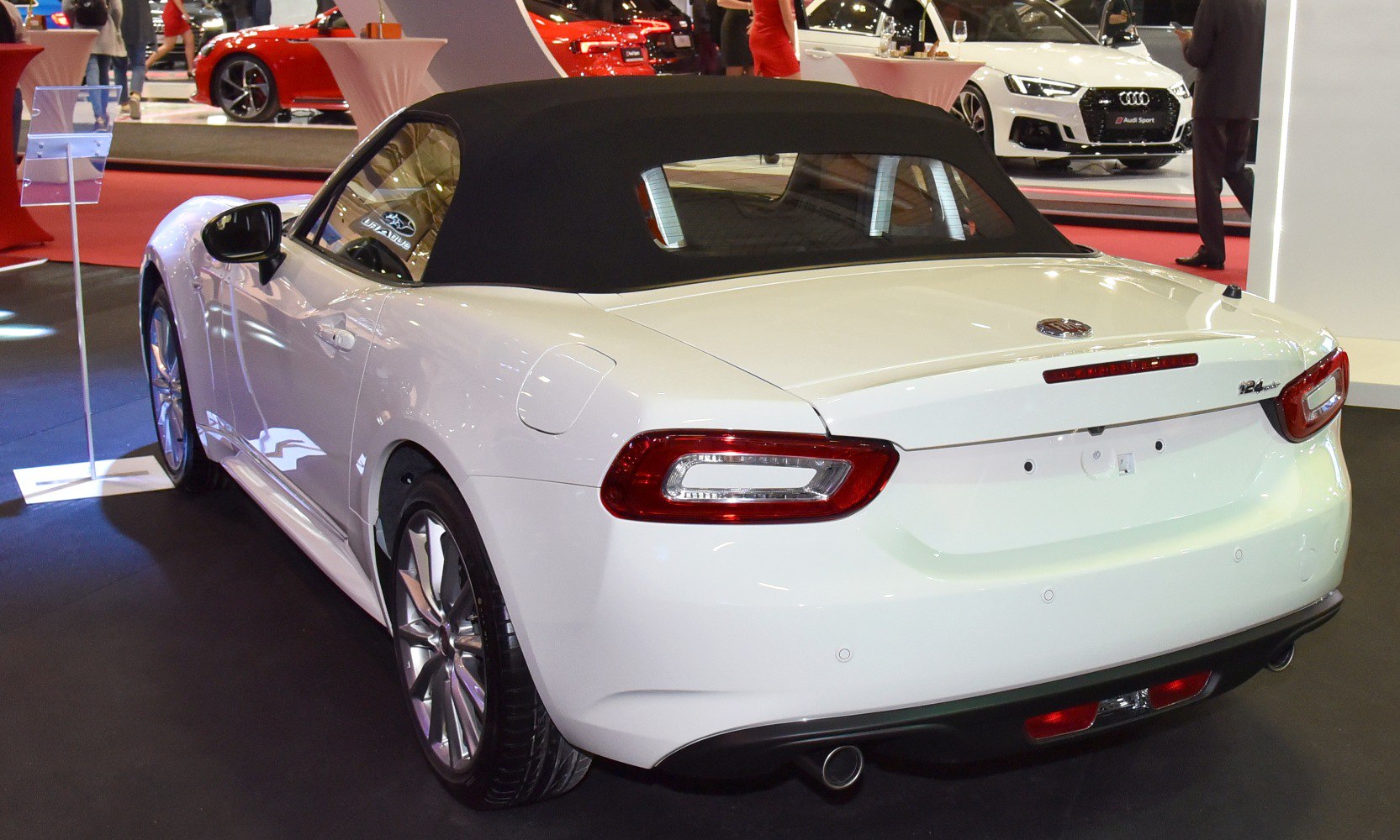 Convertible rear view with soft top, sleek taillights, rear bumper, and single exhaust pipe