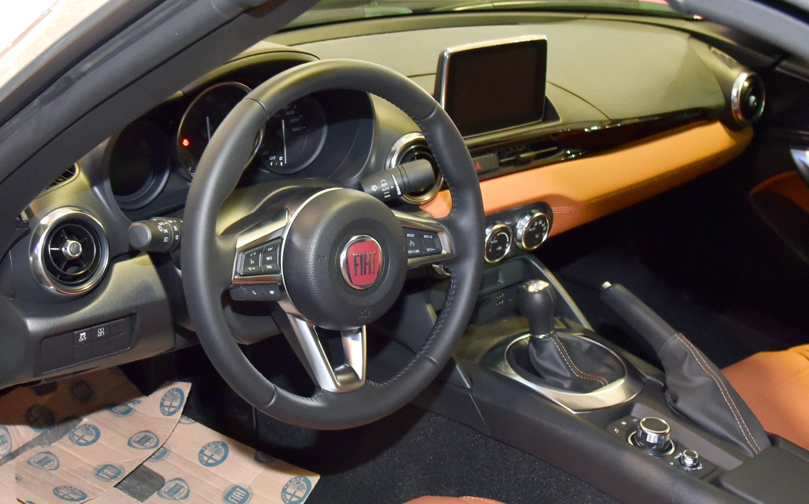 Steering wheel, dashboard with screen, gear shifter, and air vents