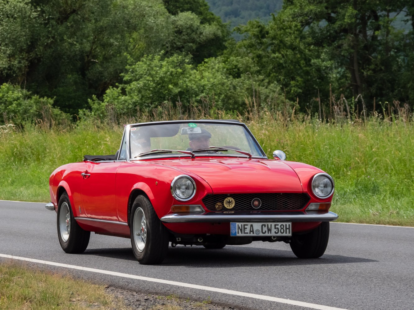 Vintage red convertible with round headlights and chrome bumper