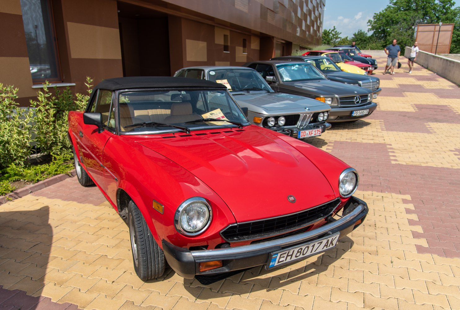 Red classic convertible with black soft top and round headlights