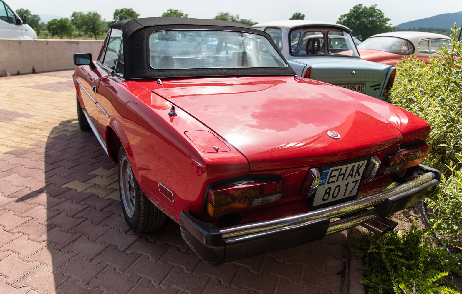 Red vintage convertible rear with black soft top and classic taillights