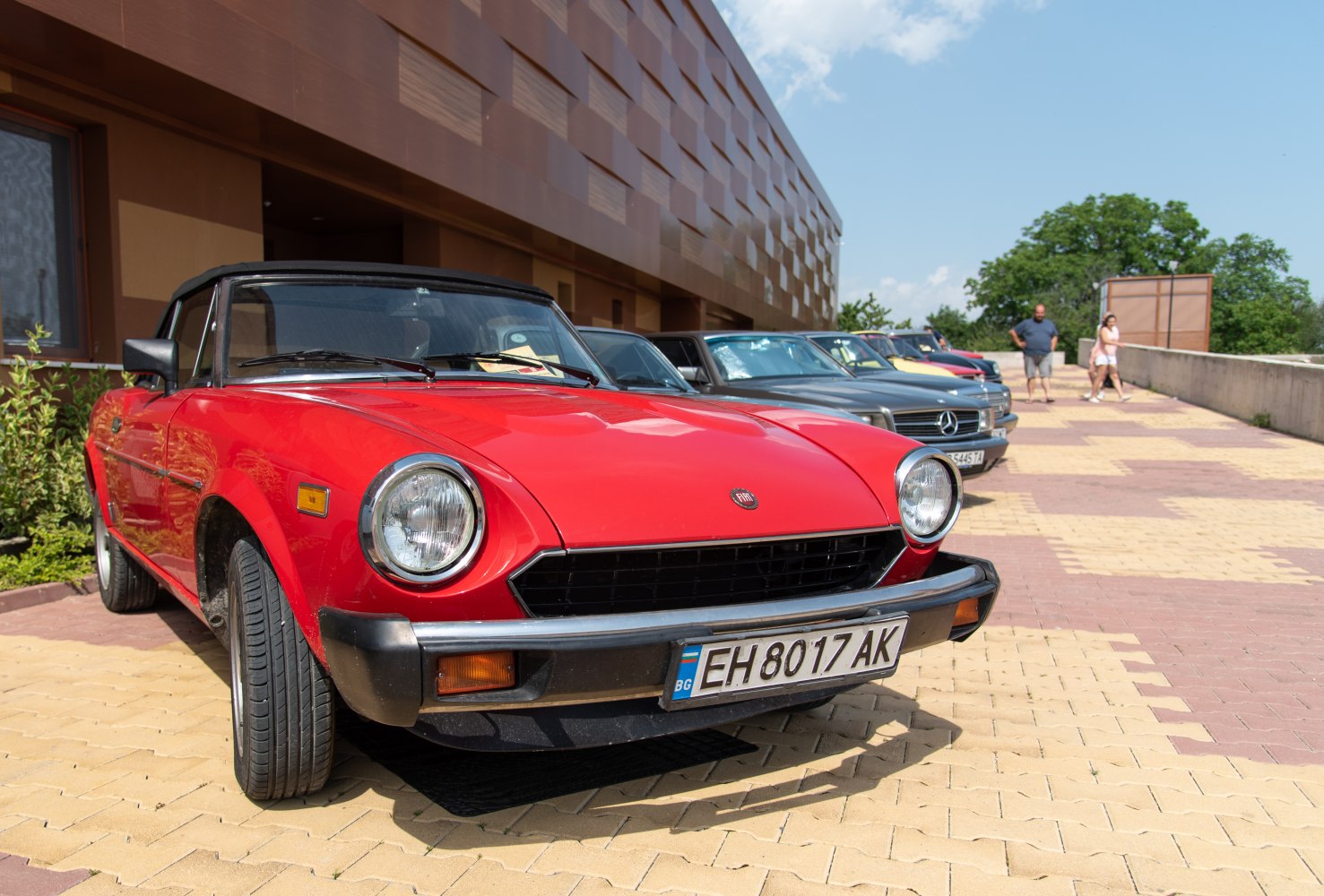 Red convertible with round headlights and black front grille
