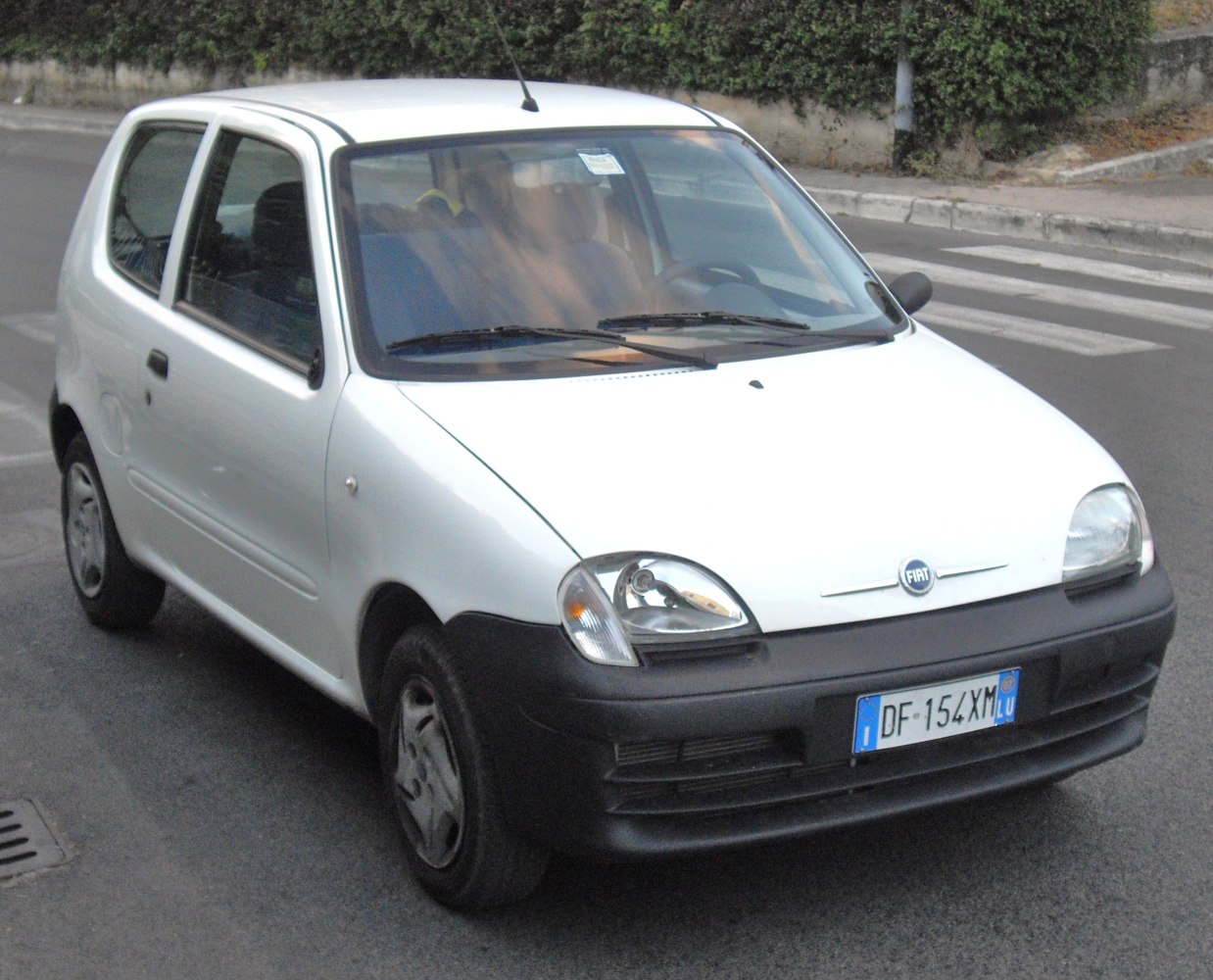 Compact white hatchback with rounded headlights and black bumper