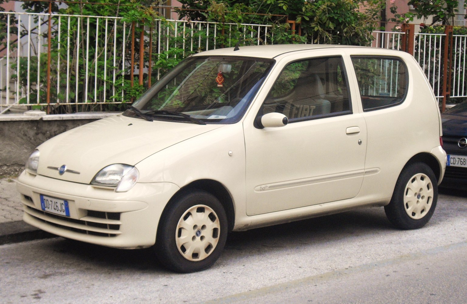 Compact ivory hatchback with rounded headlights and 3-door profile