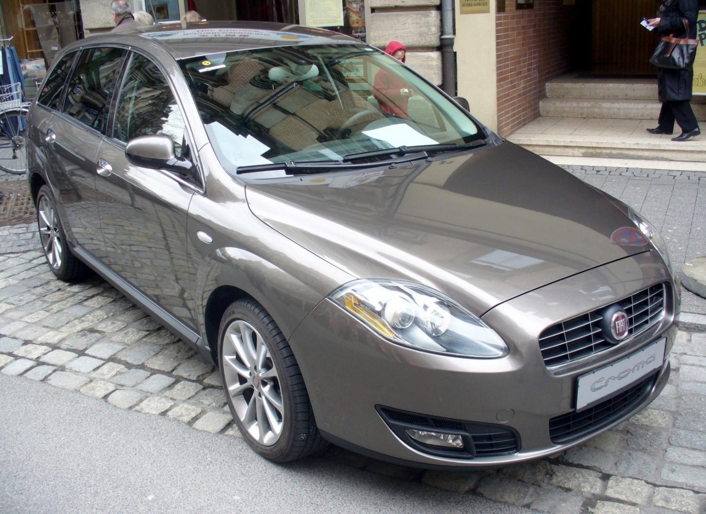 Front angle view with dual rounded headlights and alloy wheels.
