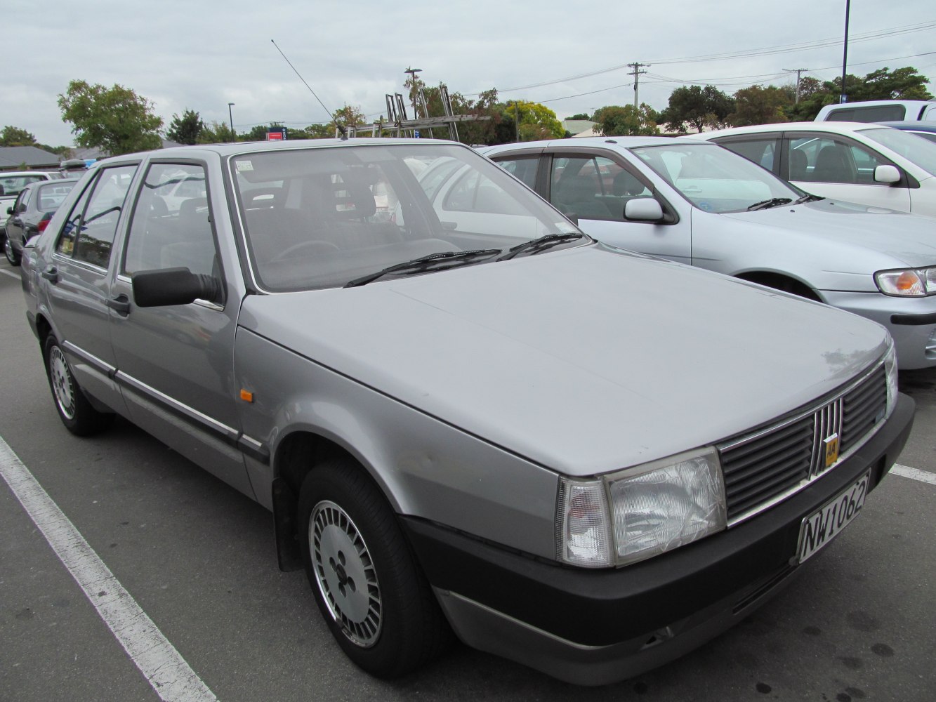 Front and side view of classic sedan with rectangular headlights and silver finish