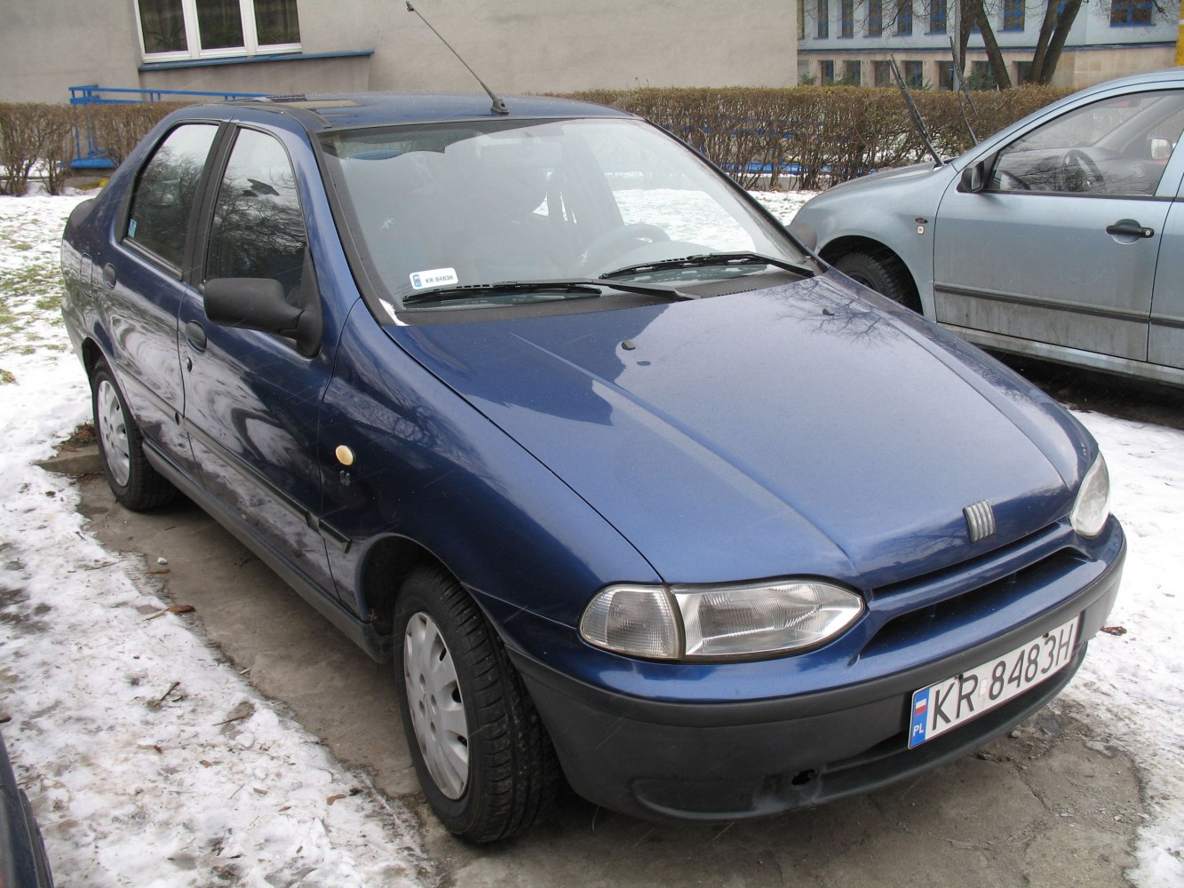 Side-front view of blue sedan with classic headlights and grille