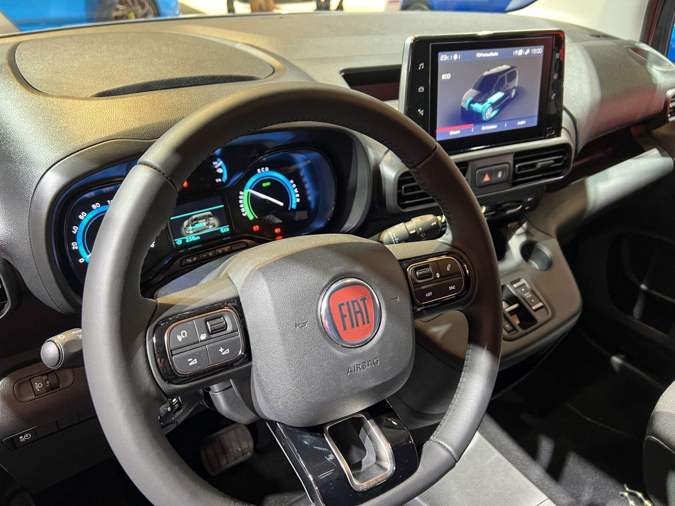 Steering wheel with controls, digital instrument cluster, touchscreen infotainment.