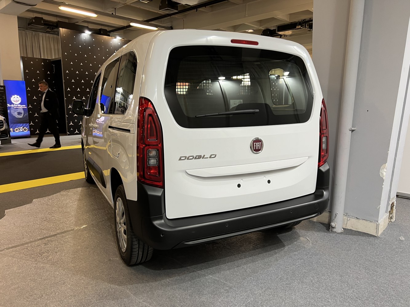 Rear view of white van with distinct vertical taillights and large rear window