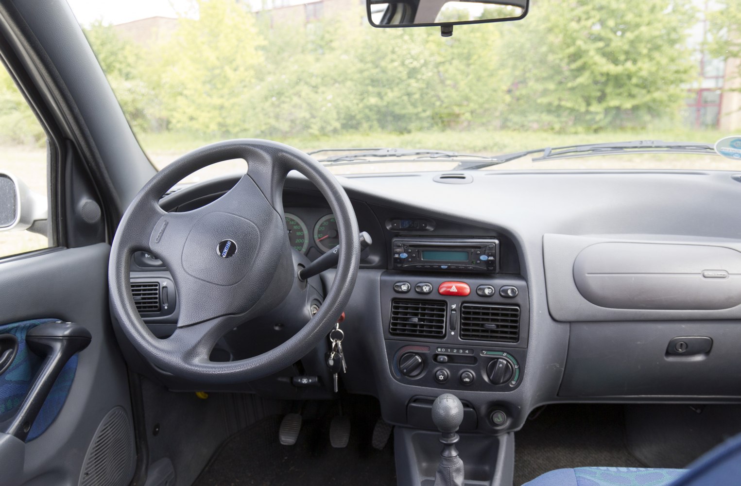 Dashboard and steering wheel layout with manual gear stick and ventilation controls