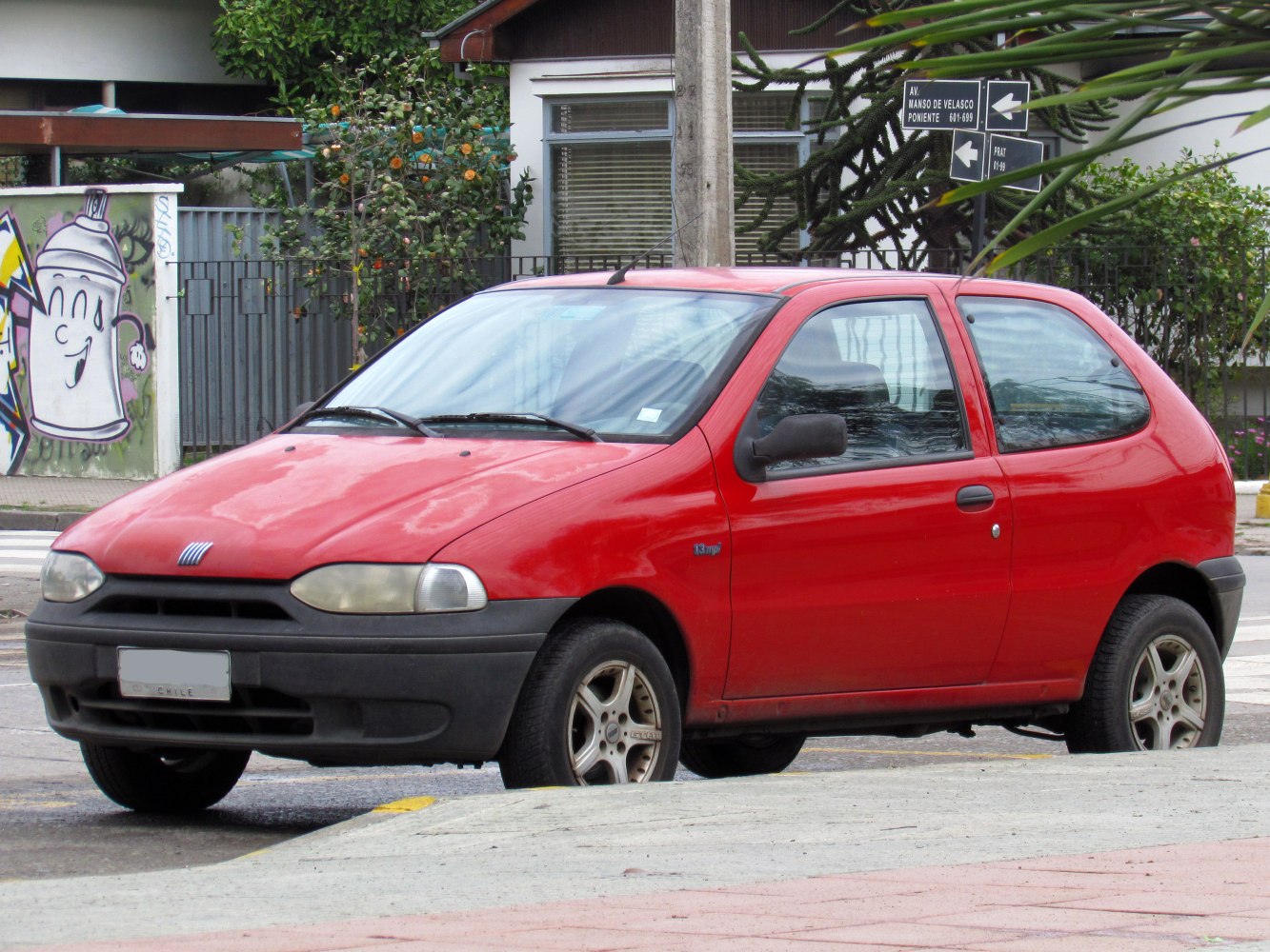 Red compact hatchback with black bumpers and rounded headlights