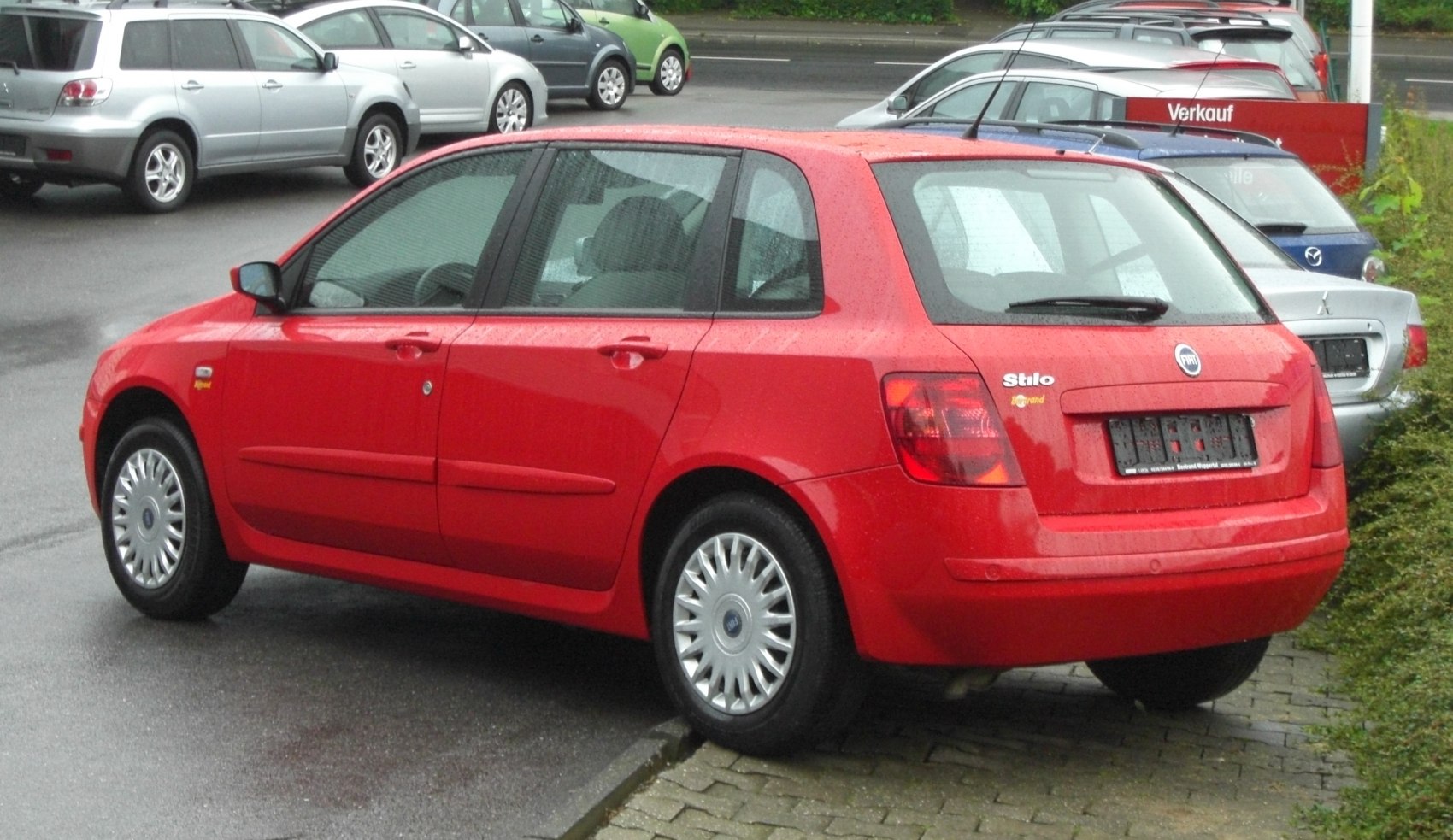5-door hatchback rear and side view with red paint and rain droplets
