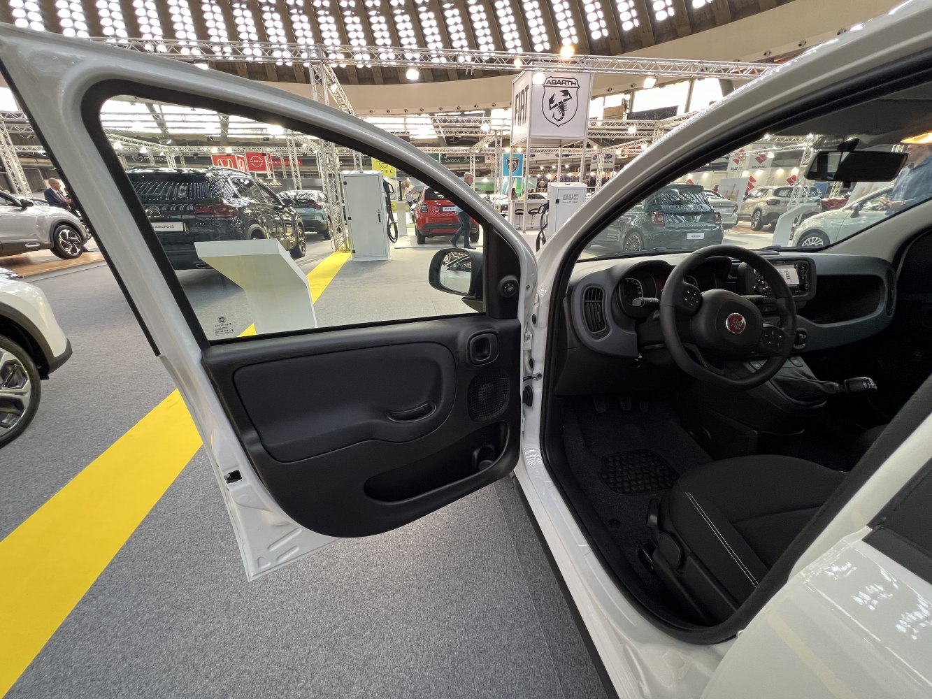 Open driver door, dashboard, steering wheel, and front seat interior