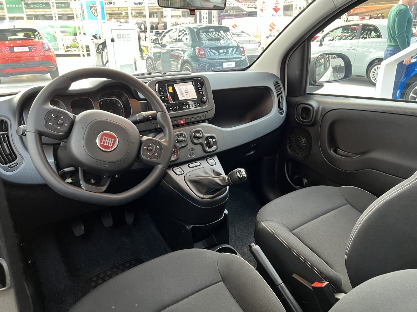 Car interior with manual gear shift and multifunction steering wheel