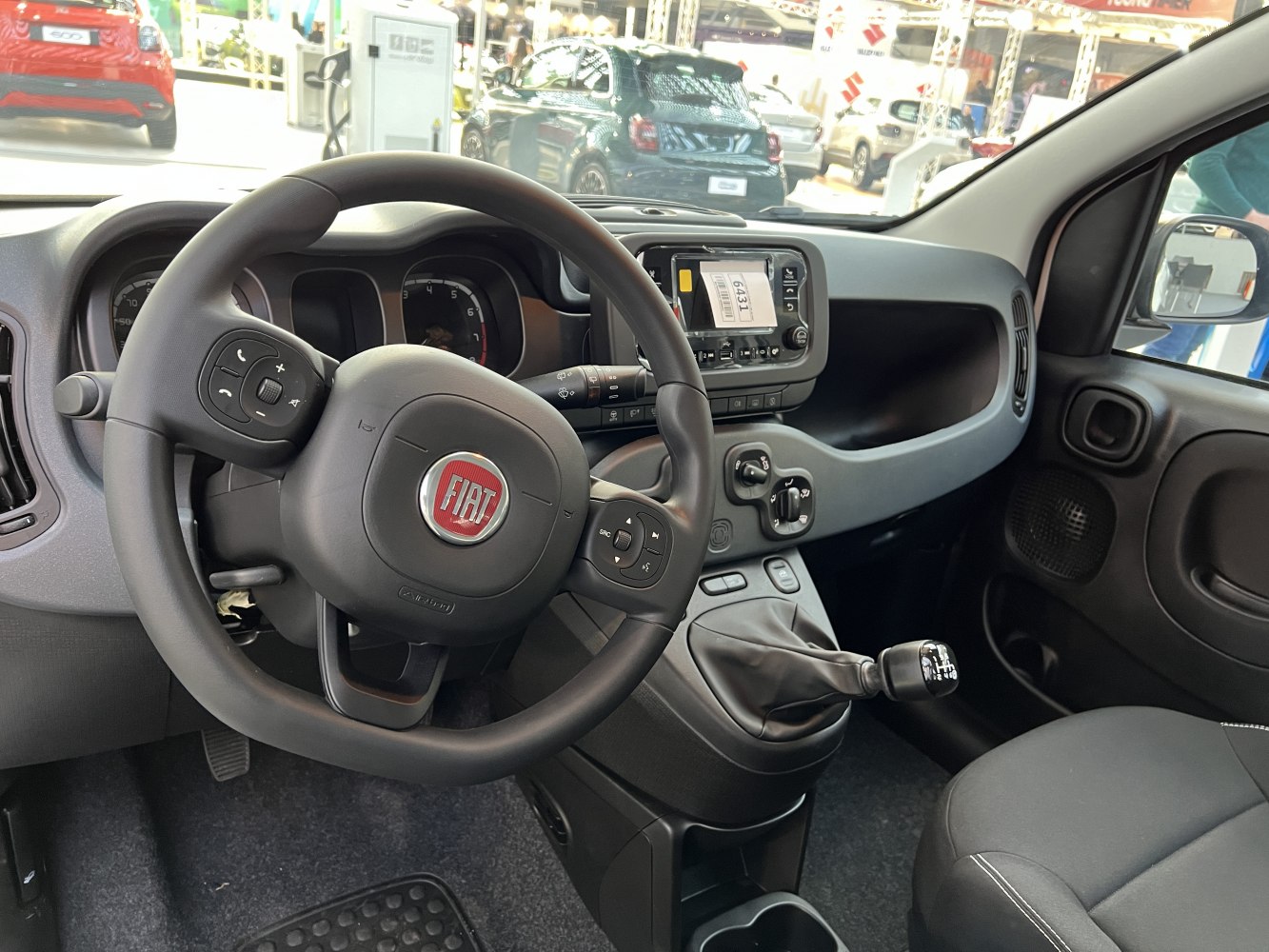 Steering wheel with control buttons and manual gear shift lever