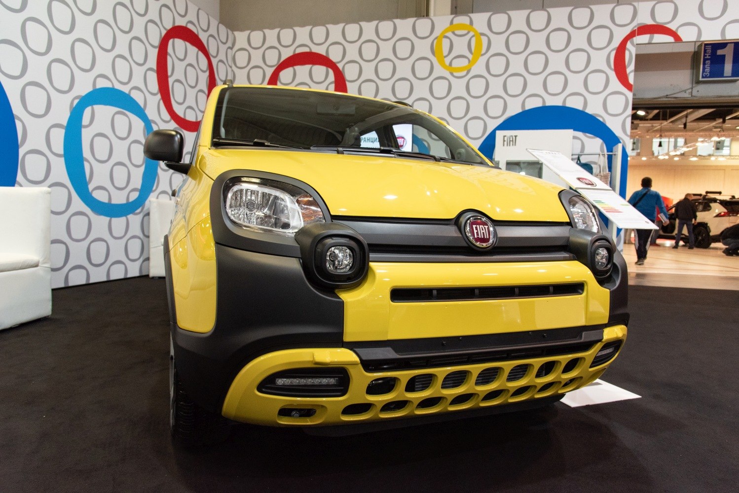 Yellow compact SUV front with distinctive round fog lights and bold grille design