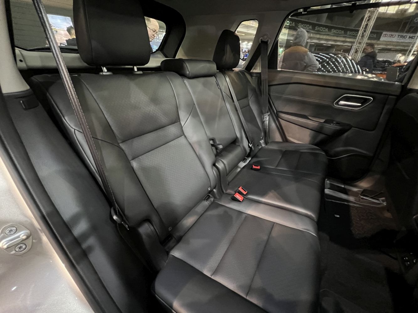Spacious black leather rear seats with seat belts and headrests.
