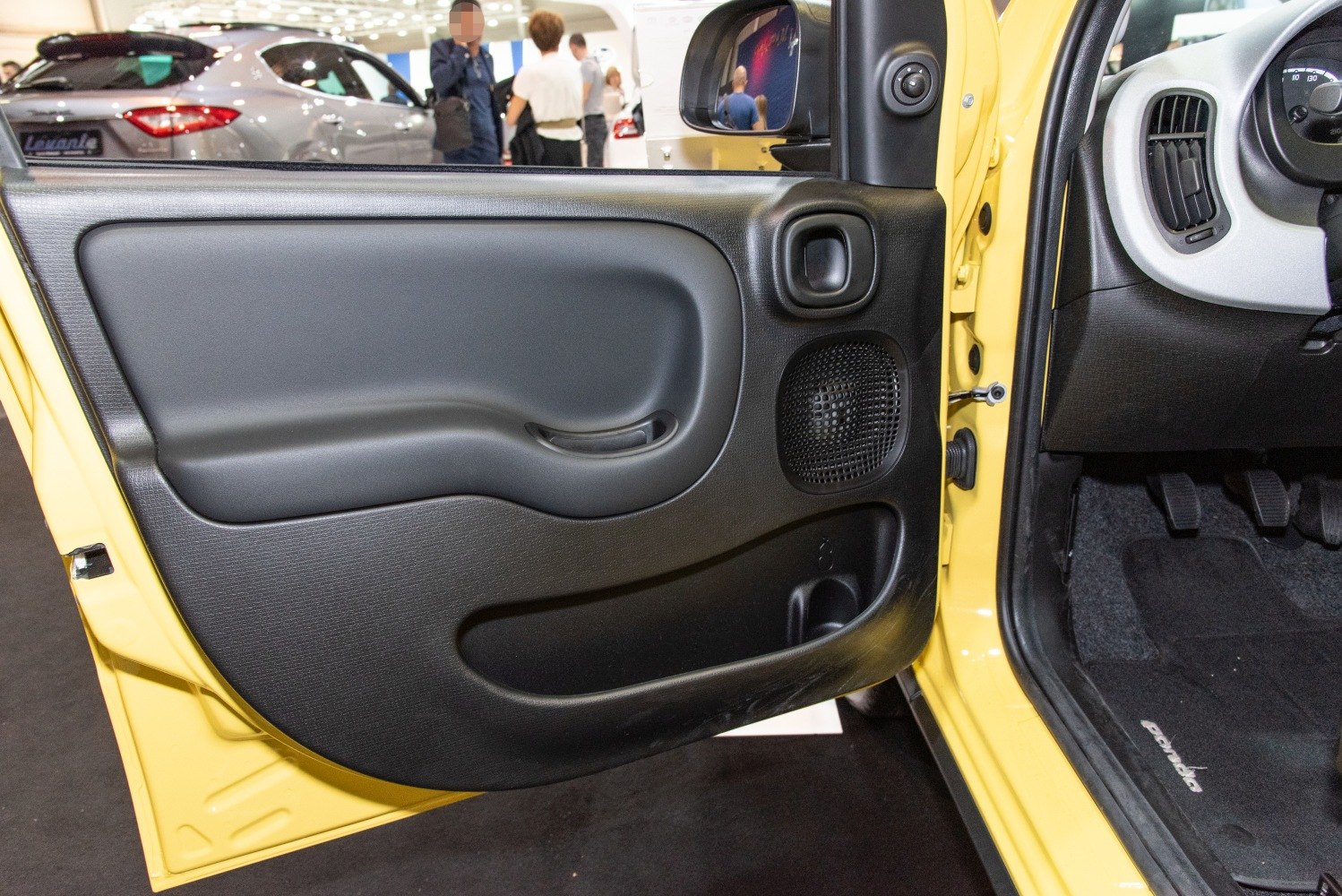 Interior door panel with handle, speaker grille, and storage compartment