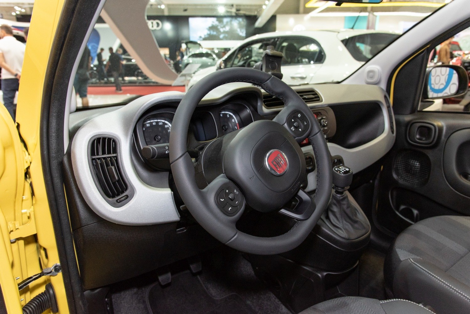 Steering wheel with controls and compact dashboard interior
