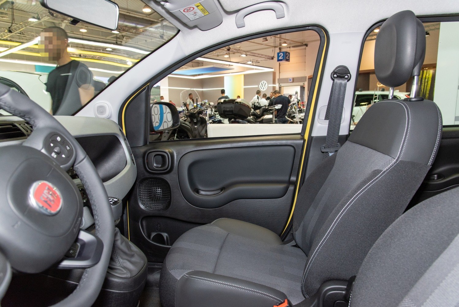 Front seat and door panel of a car interior with steering wheel.
