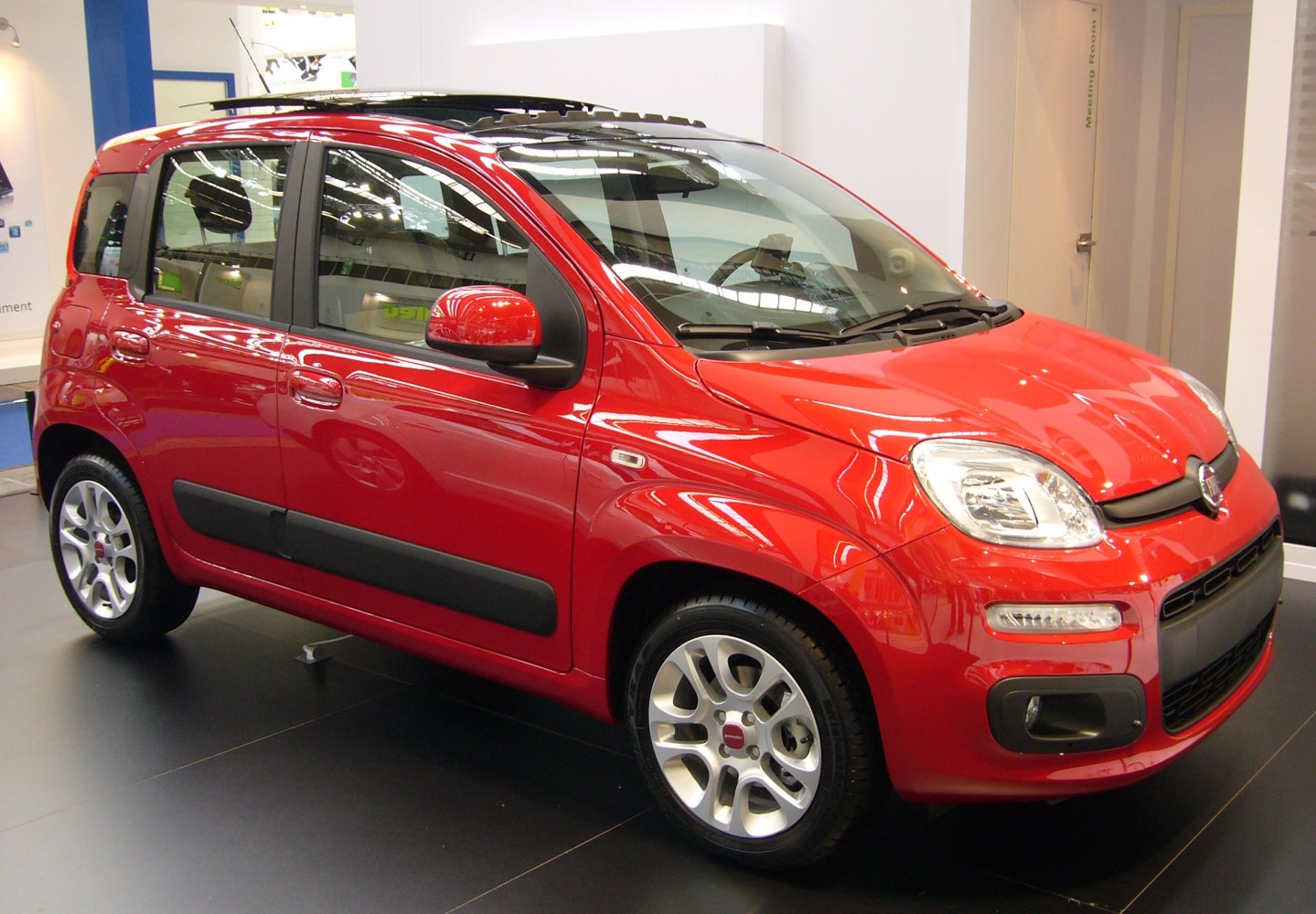 Red compact hatchback with black side moldings and alloy wheels