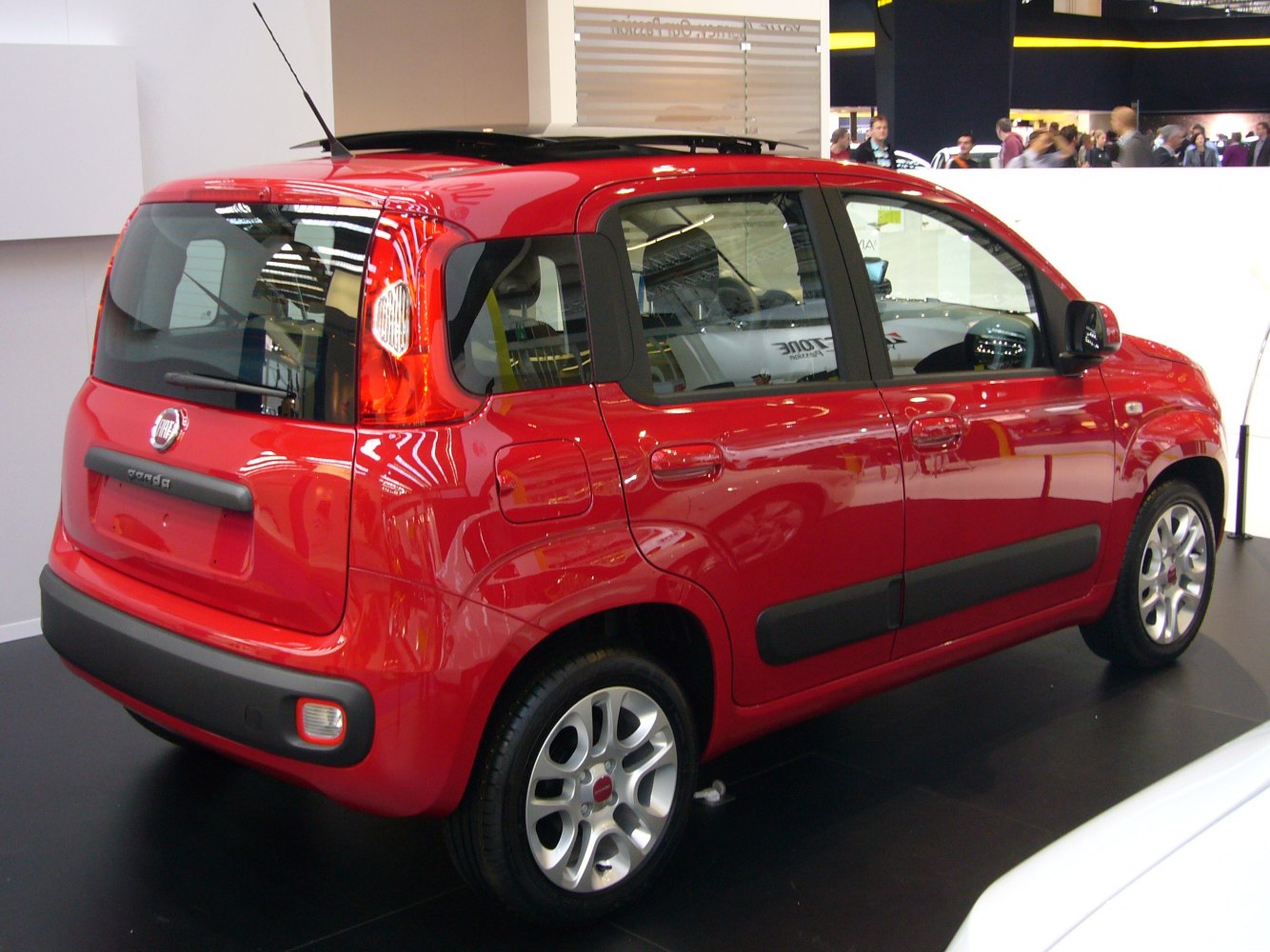 Rear side view with vertical tail lights and black side moldings on a red compact hatchback.